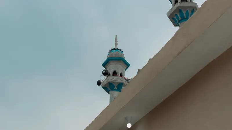 Hands exchanging a warm greeting during Ramadan with prayer beads and Quran in the background