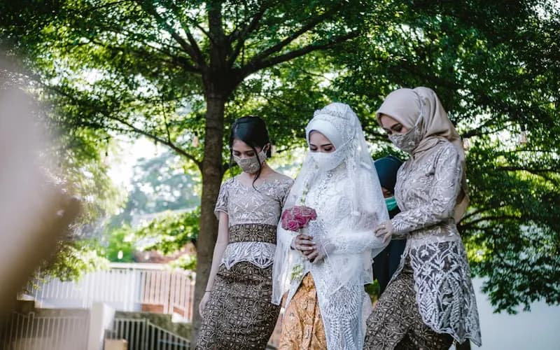 Bride in a modest Islamic wedding gown with embroidered sleeves and a matching hijab